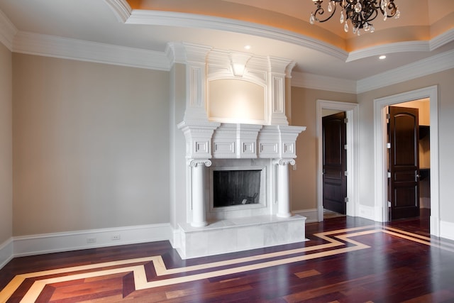 unfurnished living room featuring crown molding, a premium fireplace, dark hardwood / wood-style floors, and a notable chandelier