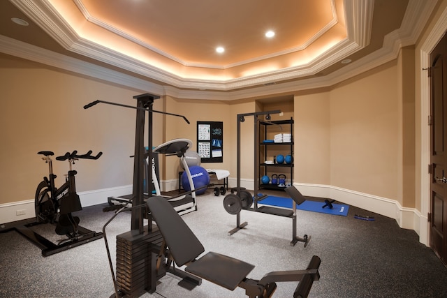 exercise area featuring crown molding, carpet floors, and a tray ceiling