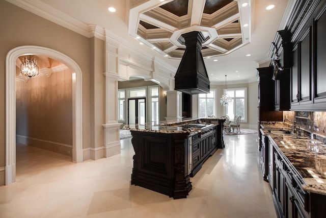 kitchen featuring decorative light fixtures, light tile flooring, ornamental molding, coffered ceiling, and dark stone counters