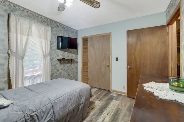 bedroom with a closet, a textured ceiling, ceiling fan, and hardwood / wood-style floors