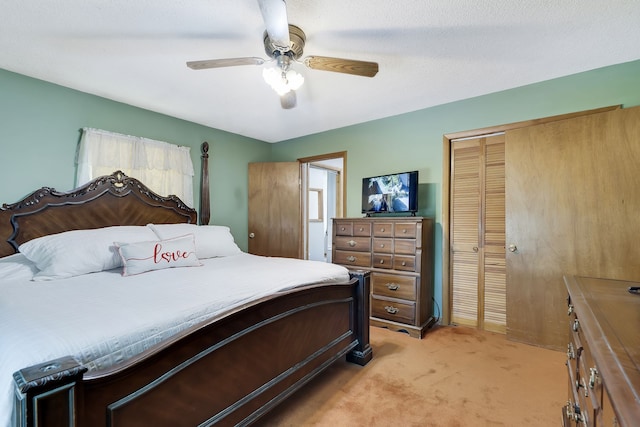 bedroom with light colored carpet, a textured ceiling, ceiling fan, and a closet