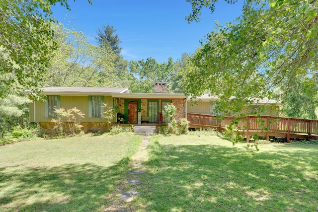 rear view of house featuring a deck and a lawn