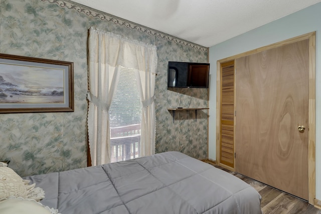 bedroom featuring a closet, hardwood / wood-style floors, and lofted ceiling