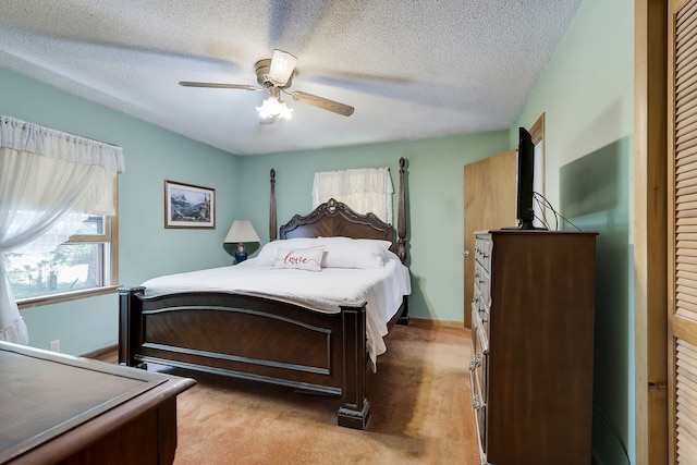 carpeted bedroom featuring ceiling fan and a textured ceiling