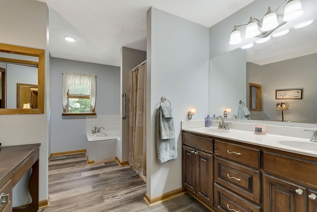 bathroom featuring wood-type flooring, dual vanity, and a bath