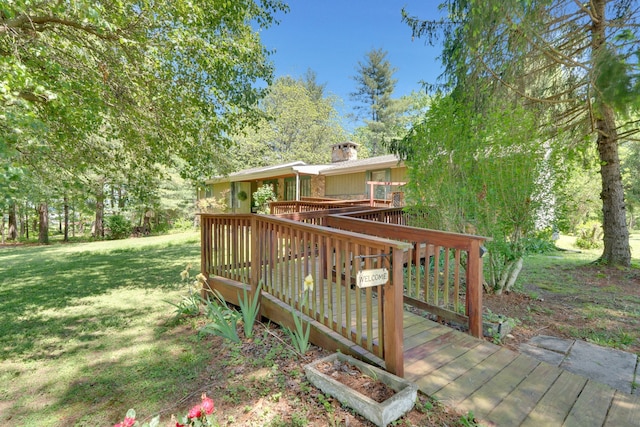 wooden terrace featuring a lawn