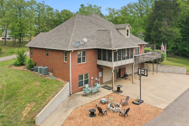 rear view of property with central AC, a yard, a sunroom, and a patio area