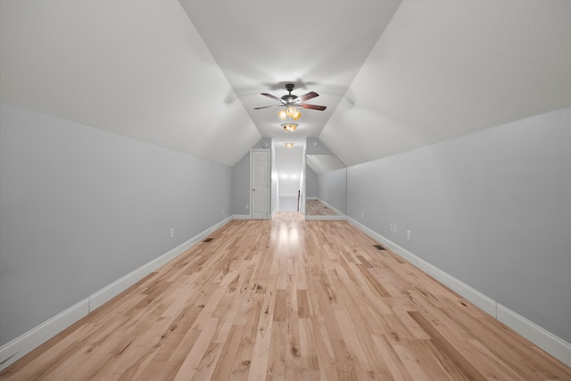 additional living space with vaulted ceiling, light hardwood / wood-style flooring, and ceiling fan