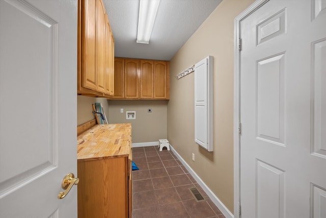 laundry room featuring washer hookup, dark tile floors, electric dryer hookup, and cabinets