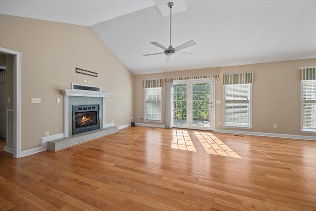 unfurnished living room featuring high vaulted ceiling, ceiling fan, a fireplace, and light wood-type flooring