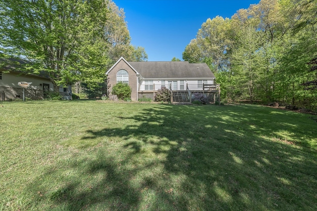 view of front facade featuring a front yard and a wooden deck