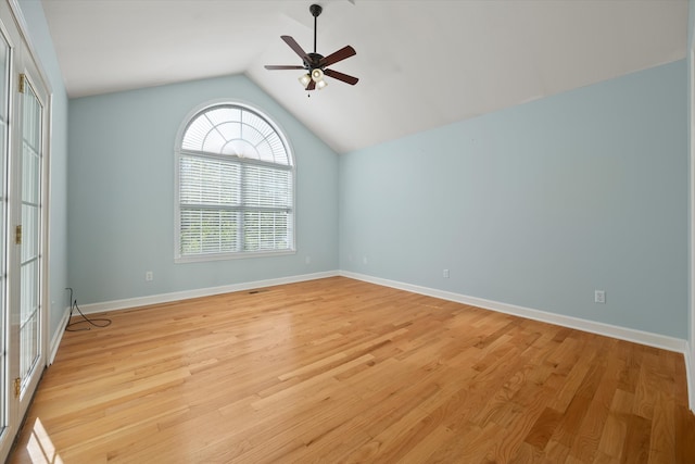 empty room featuring lofted ceiling, a wealth of natural light, ceiling fan, and light wood-type flooring