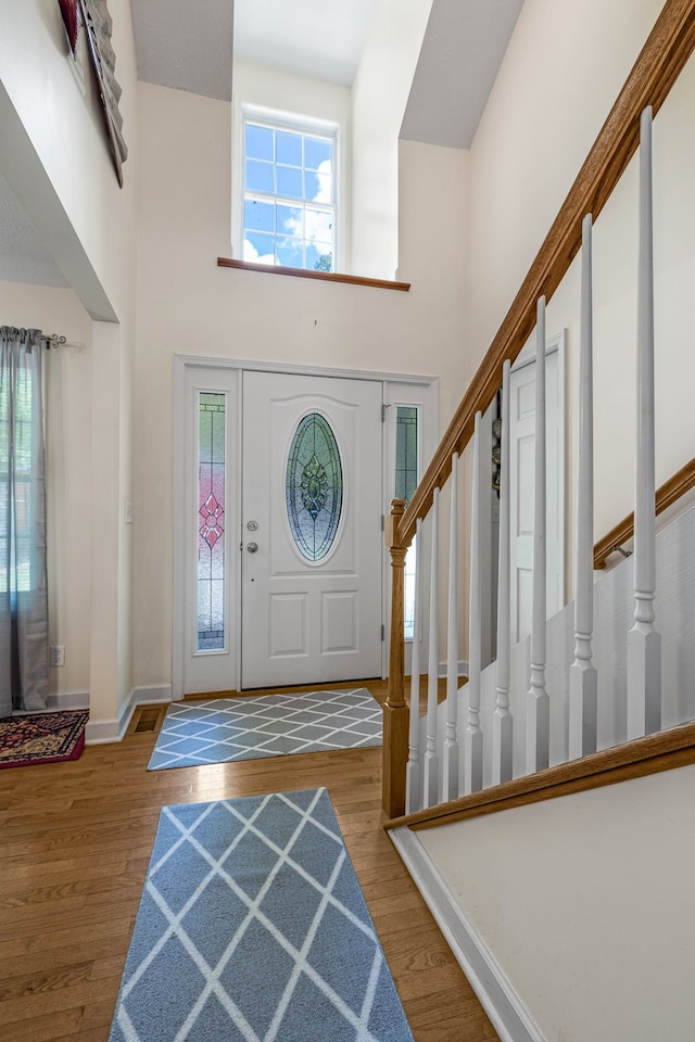 entryway with a high ceiling and hardwood / wood-style flooring