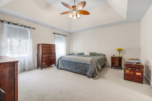 bedroom with a tray ceiling, ceiling fan, and light colored carpet