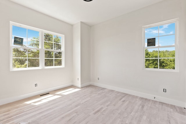 spare room with a healthy amount of sunlight and light hardwood / wood-style flooring