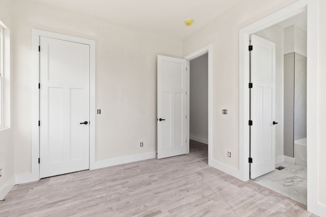 unfurnished bedroom featuring light hardwood / wood-style floors and ensuite bathroom