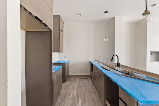 kitchen with pendant lighting and light hardwood / wood-style floors