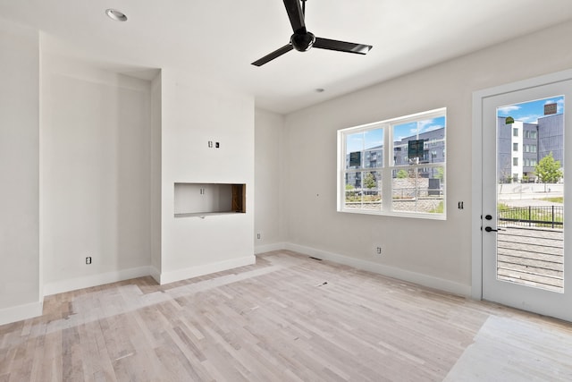 unfurnished living room with light wood-type flooring and ceiling fan