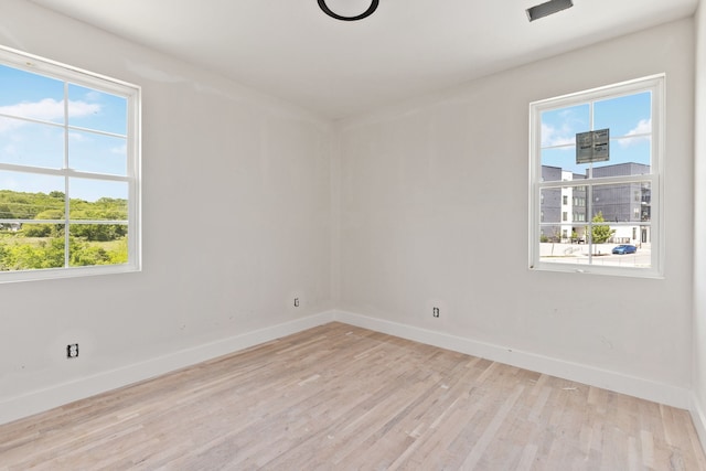 empty room with light wood-type flooring and a healthy amount of sunlight