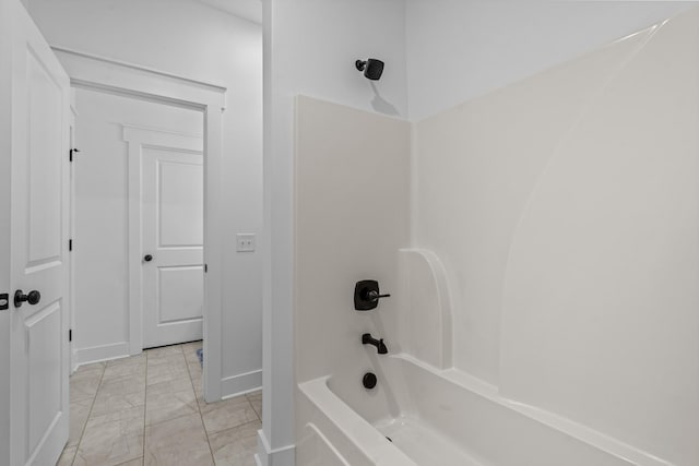 bathroom with bathtub / shower combination and baseboards