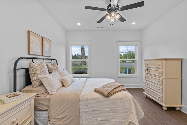 bedroom with dark wood-style floors, recessed lighting, visible vents, and baseboards