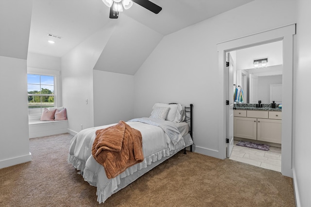 carpeted bedroom with baseboards, visible vents, vaulted ceiling, and connected bathroom