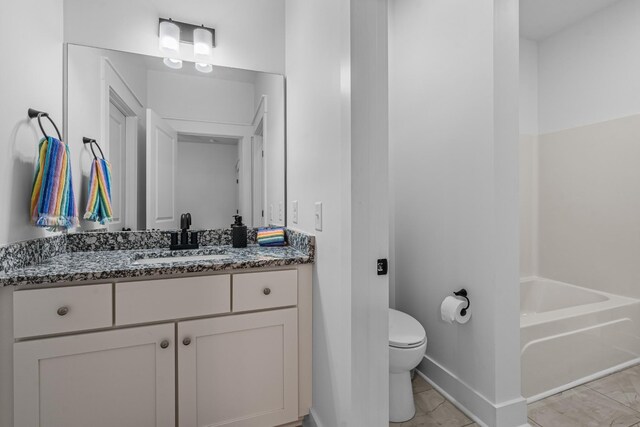 full bath featuring toilet, a tub, baseboards, and vanity