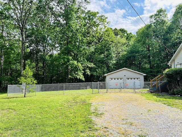 view of yard featuring a garage and an outbuilding