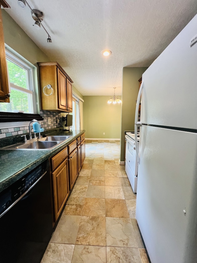 kitchen featuring a notable chandelier, decorative backsplash, sink, white appliances, and a textured ceiling