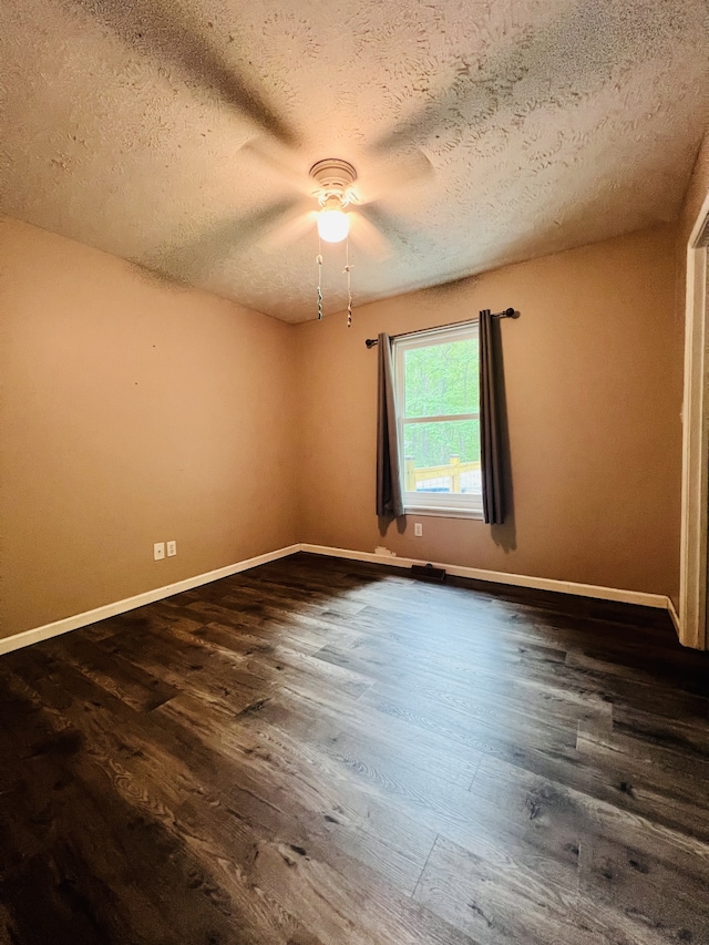 spare room featuring a textured ceiling and dark wood-type flooring