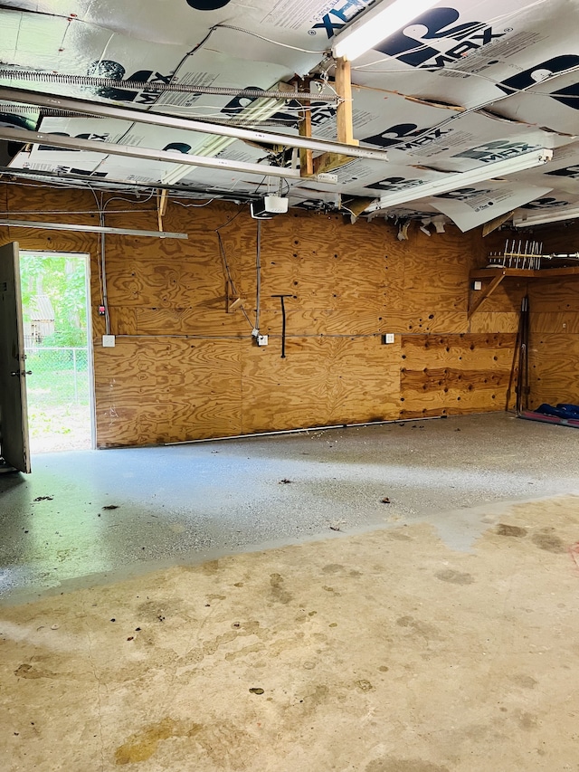 garage with a garage door opener and wooden walls