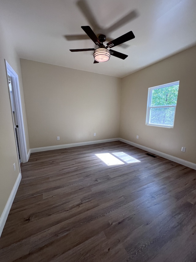 empty room featuring ceiling fan and dark hardwood / wood-style flooring