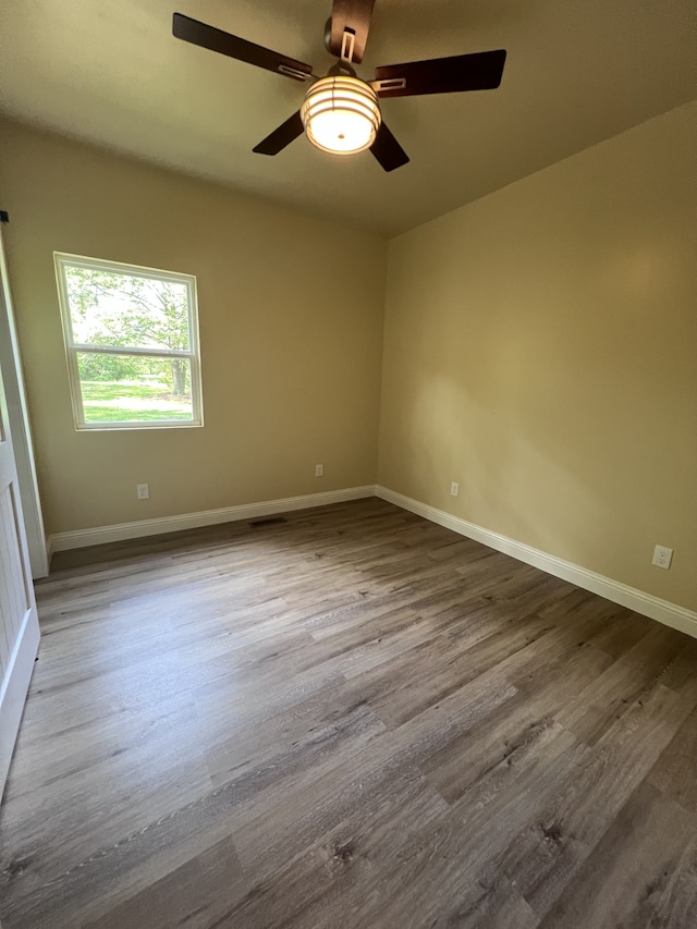 empty room with hardwood / wood-style floors and ceiling fan