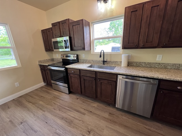 kitchen featuring plenty of natural light, appliances with stainless steel finishes, light hardwood / wood-style floors, and sink