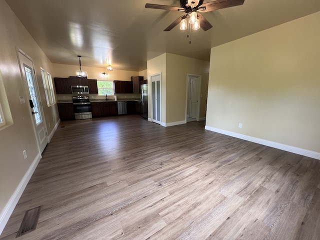 unfurnished living room featuring sink, ceiling fan, and hardwood / wood-style floors