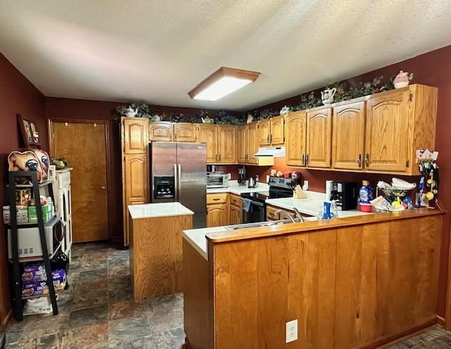 kitchen featuring appliances with stainless steel finishes, kitchen peninsula, and a textured ceiling