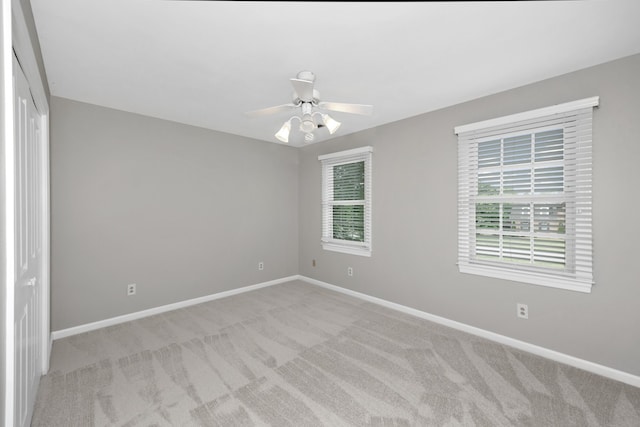 carpeted spare room with ceiling fan