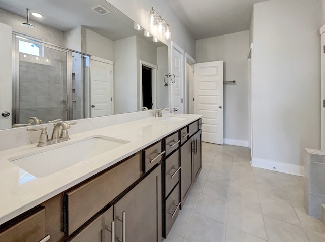 bathroom with dual sinks, oversized vanity, tile floors, and a shower with shower door