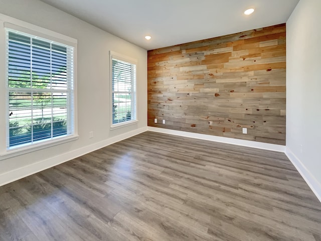 empty room with dark hardwood / wood-style floors and wood walls