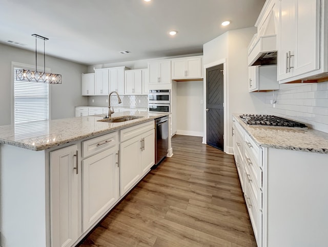 kitchen featuring white cabinetry, appliances with stainless steel finishes, sink, hardwood / wood-style flooring, and tasteful backsplash