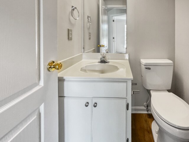 bathroom featuring wood-type flooring, vanity, and toilet