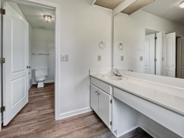 bathroom with wood-type flooring, vanity, and toilet