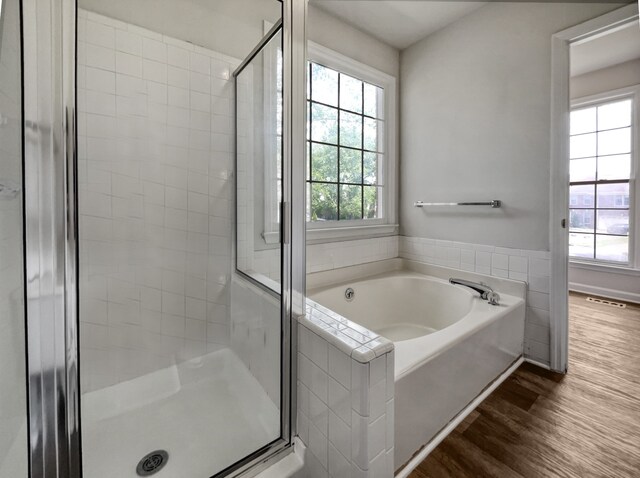 bathroom featuring separate shower and tub and hardwood / wood-style floors