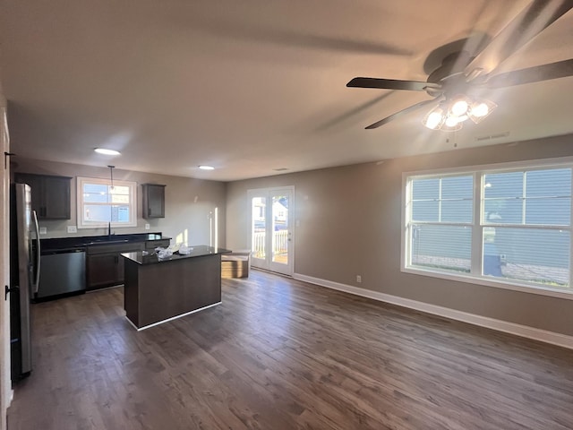 kitchen featuring ceiling fan, sink, stainless steel appliances, dark hardwood / wood-style flooring, and a kitchen island