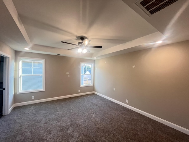 carpeted empty room featuring a tray ceiling and ceiling fan