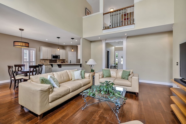 808 Seven Points Cv, Hermitage, TN 37076 - living room featuring a towering ceiling, ornate columns, and dark wood-type flooring