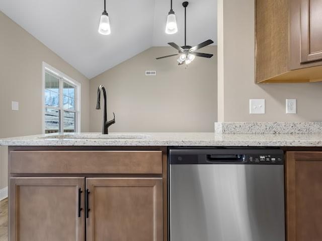 kitchen featuring vaulted ceiling, decorative light fixtures, sink, stainless steel dishwasher, and light stone countertops