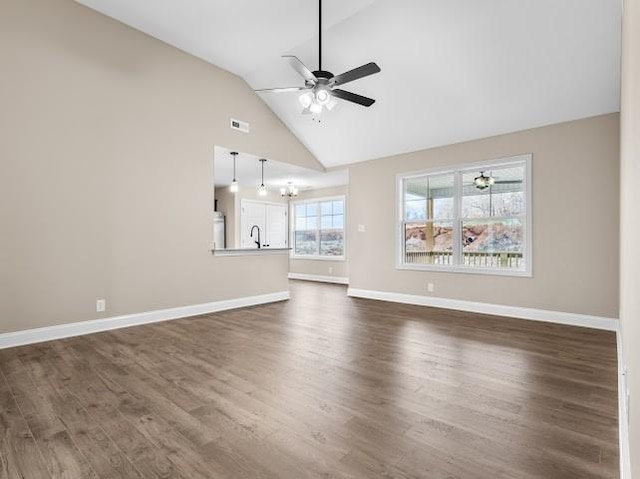 unfurnished living room with lofted ceiling, dark wood-type flooring, sink, and ceiling fan