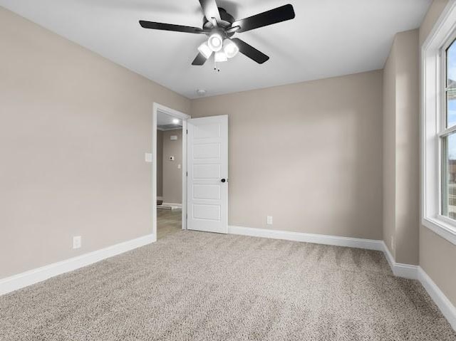 unfurnished room with ceiling fan, a healthy amount of sunlight, and carpet