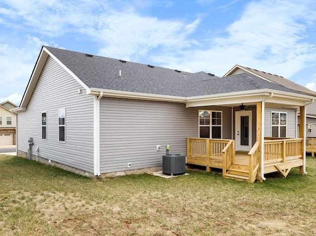 rear view of property with central AC unit, ceiling fan, a yard, and a deck